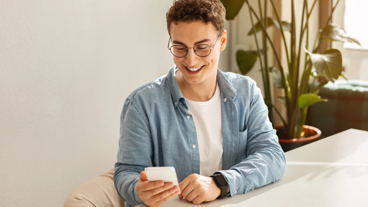 Man smiling at mobile phone